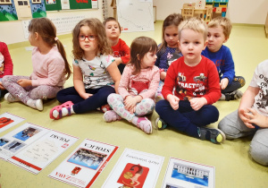 04 Dzieci siedzą przed ilustracjami dotyczącymi stolicy Polski